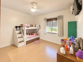 Quarto com cama de beliche e piso de madeira clara em um imóvel no Brasil.