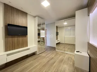 Sala de estar com piso de madeira e espelhos.