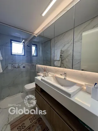 Foto de um banheiro moderno com revestimento de mármore e bancada branca.