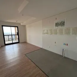 Ambiente interno com piso de madeira e porta de vidro voltada para o exterior.
