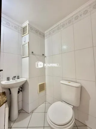 Foto de um banheiro com revestimento de azulejos brancos.