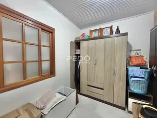 Interior de um cômodo com armário de madeira e janela no ambiente.