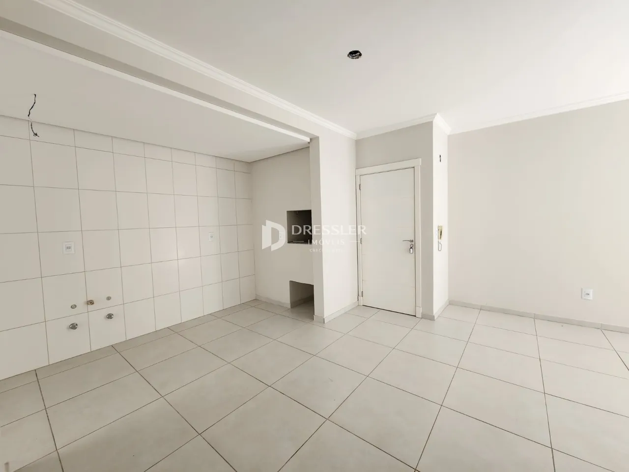 Hall de entrada com piso de cerâmica e paredes brancas.