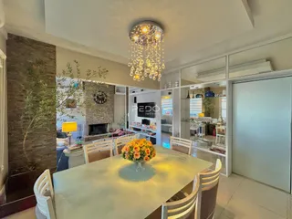Vista de uma sala de jantar iluminada com mesa de madeira clara.