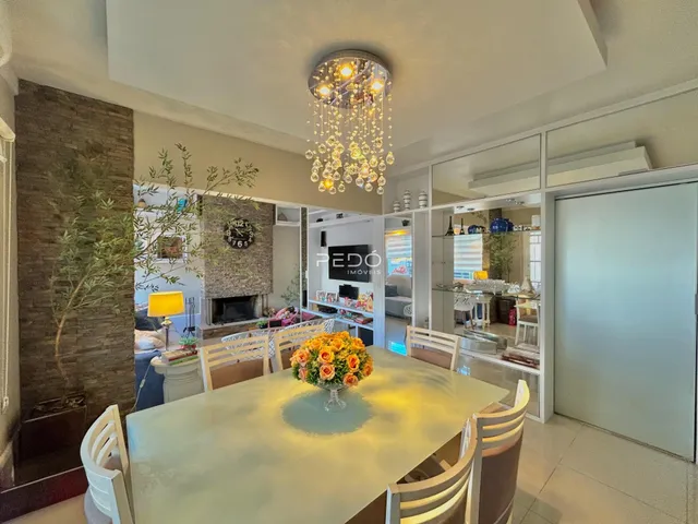 Vista de uma sala de jantar iluminada com mesa de madeira clara.