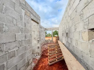 Vista de um corredor entre paredes de concreto em construção.