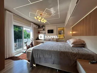 Quarto com cama grande e porta de vidro com vista para o exterior.