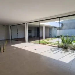 Vista de um espaço interno com portas de vidro que dão acesso a uma área externa.