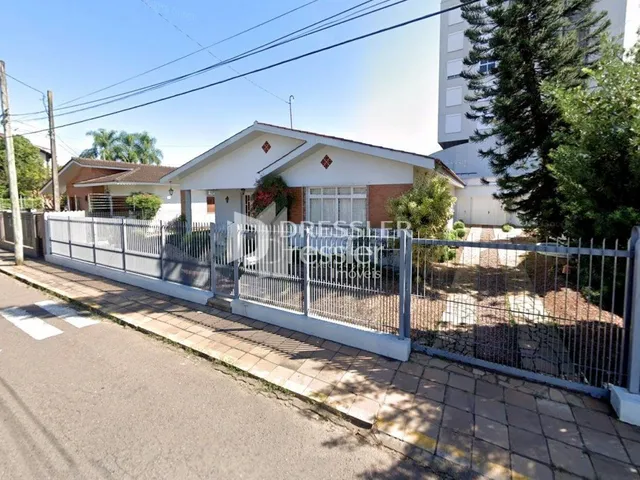 Fachada de uma residência em Lajeado, Brasil, com cerca e muro frontal.