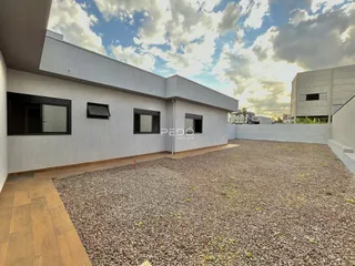 Vista externa de uma casa moderna em Lajeado com quintal de cascalho.