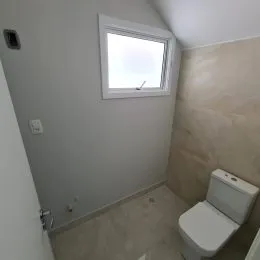 Foto de um ambiente interno com parede clara e janela.