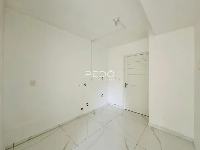 Hall de uma propriedade em Lajeado, Brasil, com paredes brancas e piso de porcelanato.