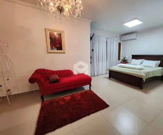 Sala de estar com sofá vermelho e tapete na residência.