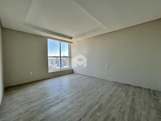 Ambiente interno de uma sala com vista para a cidade.