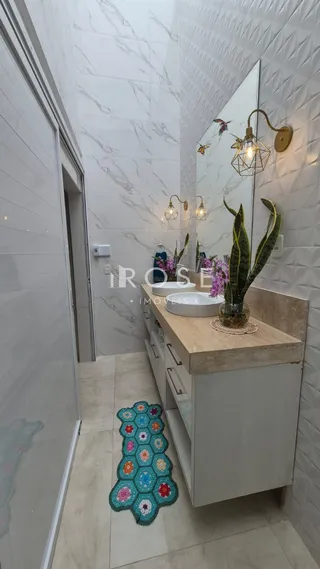 Interior de um banheiro moderno com revestimento branco e bancada de madeira.