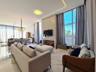 Sala de estar com sofá e janelas amplas em um imóvel.