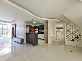 Sala de estar com piso claro e paredes brancas.