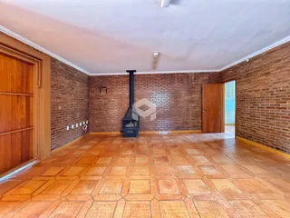 Sala de estar com paredes de tijolo aparente e piso de cerâmica.