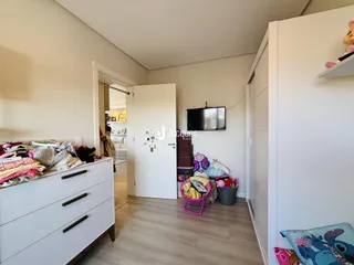 Hall de entrada com armário e móveis brancos.