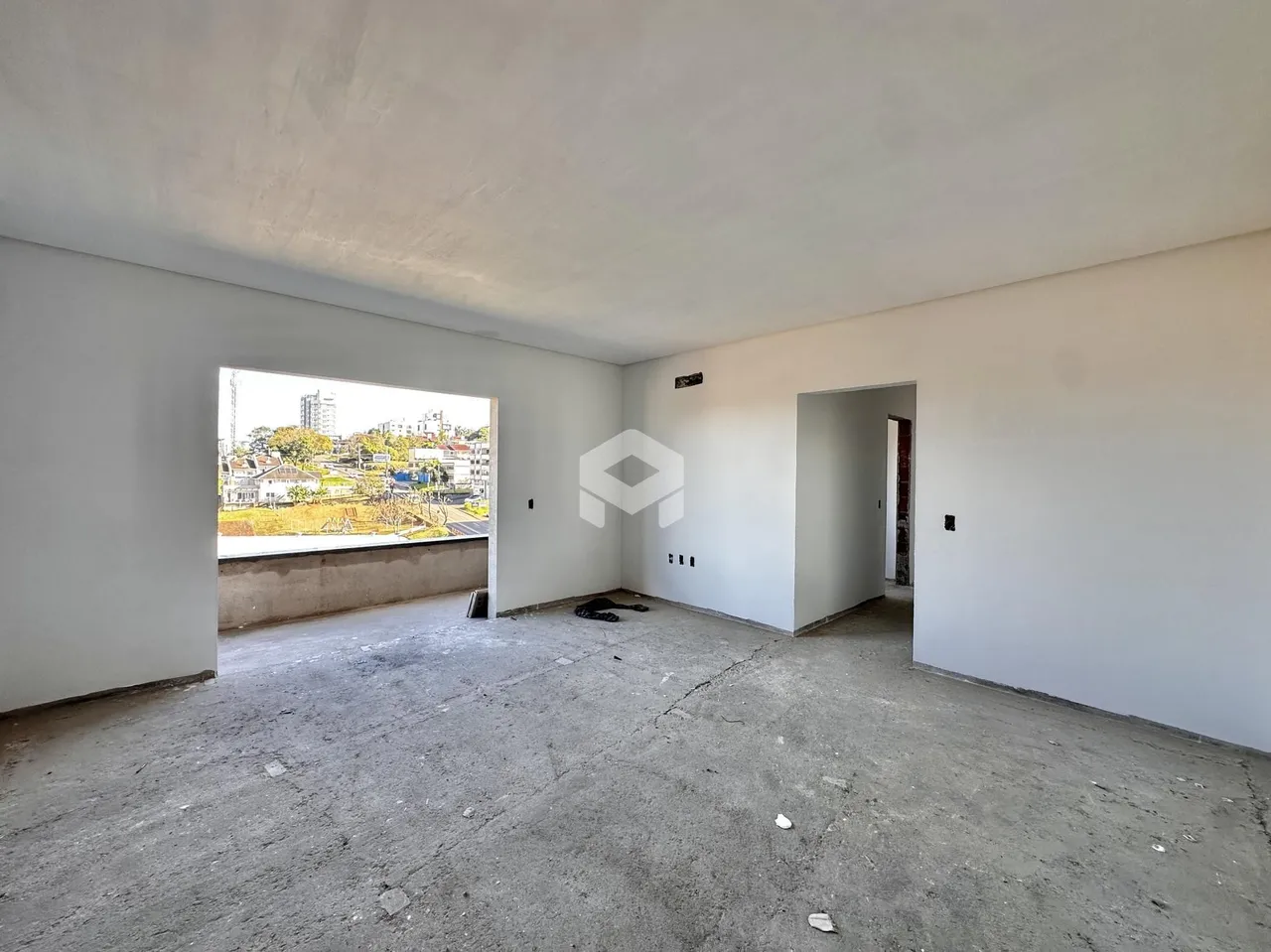 Espaço interno de uma residência com vista para a paisagem urbana.