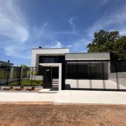 Fachada moderna de uma residência em Lajeado, Brasil, com cerca e paisagismo.