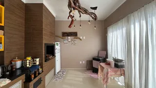 Uma sala de estar com painéis de madeira e cortinas brancas.