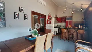 Ambiente interno de uma sala de jantar com mesa de madeira e cadeiras.
