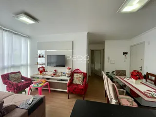 Sala de estar com decoração vermelha e piso de madeira clara.