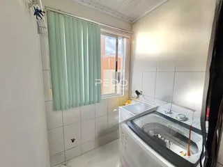 Foto de um interior com revestimento de azulejos brancos e uma janela.