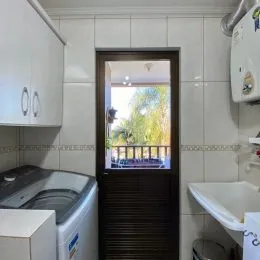 Foto de um interior com revestimento de azulejos brancos e um eletrodoméstico visível.