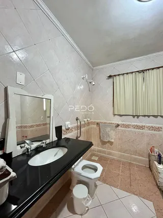 Foto de um banheiro com revestimento de cerâmica e louças sanitárias.
