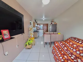 Ambiente interno de uma sala de estar com área de jantar e quarto em um imóvel no Brasil.