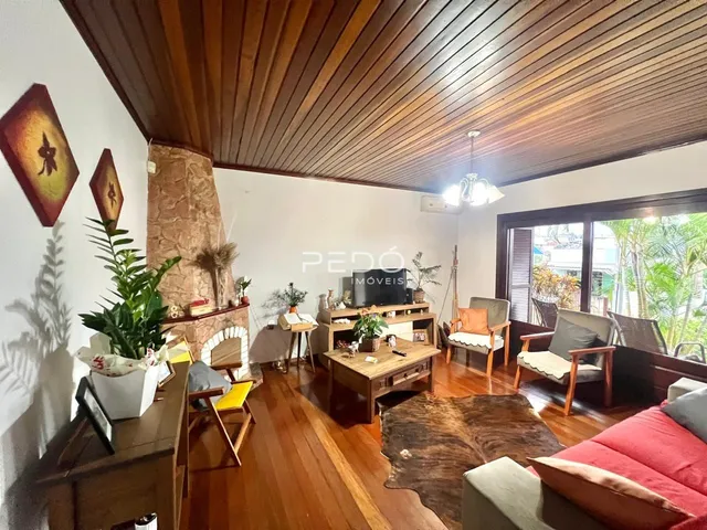 Sala de estar com piso de madeira e lareira em ambiente residencial.