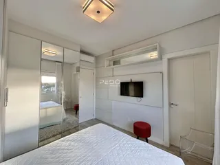 Quarto com cama e armários em um apartamento.