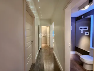 Corredor interno de uma residência com piso de madeira.