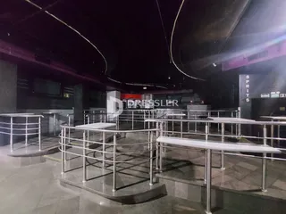 Foto de um corredor interno com grades de metal e teto curvo.