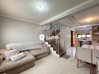 Sala de estar com sofá grande e piso de cerâmica em um imóvel em Lajeado.