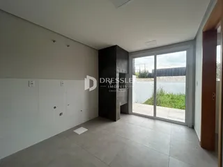 Interior de um ambiente com paredes brancas e piso de concreto em uma residência.