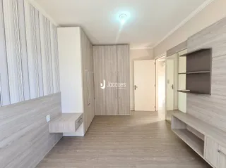 Ambiente interno com piso de madeira clara e armários embutidos.