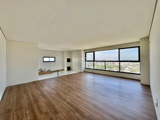 Sala de estar ampla com piso de madeira e vista panorâmica da cidade.
