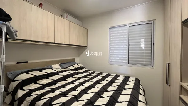 Quarto com cama e armários de madeira na sala.