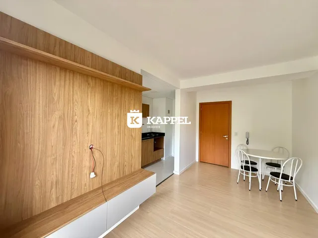 Ambiente interno com painel de madeira e mesa de jantar em um imóvel.