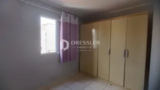 Vista interna de um cômodo com armários em madeira e janela.