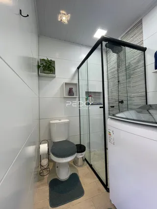Foto de um banheiro com piso de cerâmica e box de vidro.
