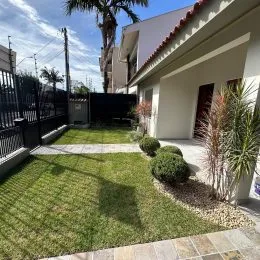 Área externa gramada em frente à residência.
