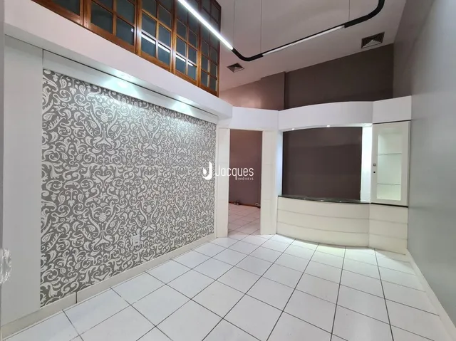Espaço interno com piso de cerâmica branca e parede decorada.