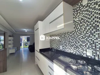 Cozinha moderna com armários brancos e revestimento de azulejos pretos e brancos.
