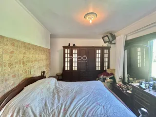 Quarto com cama de madeira e painel decorativo em uma residência.