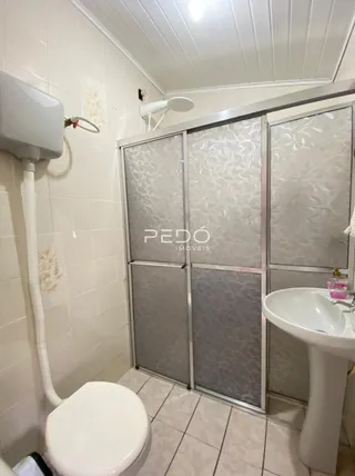 Foto de um banheiro com revestimento branco e box de vidro.