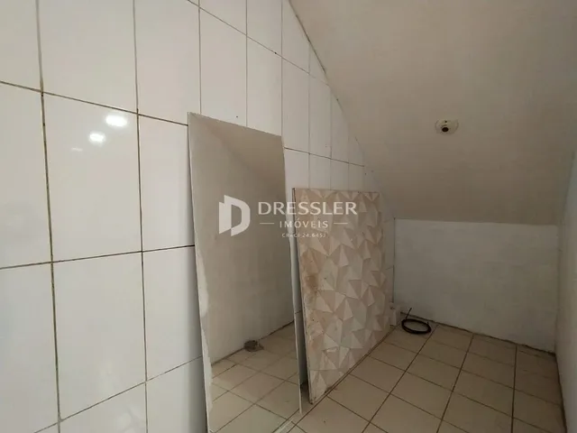 Parede interna com revestimento cerâmico branco em um ambiente residencial.